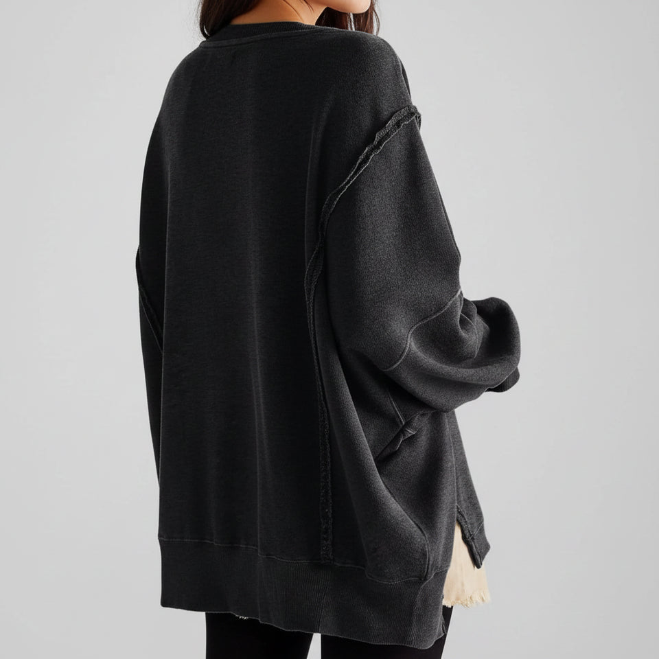 Exposed seam detail on women's black sweatshirt
